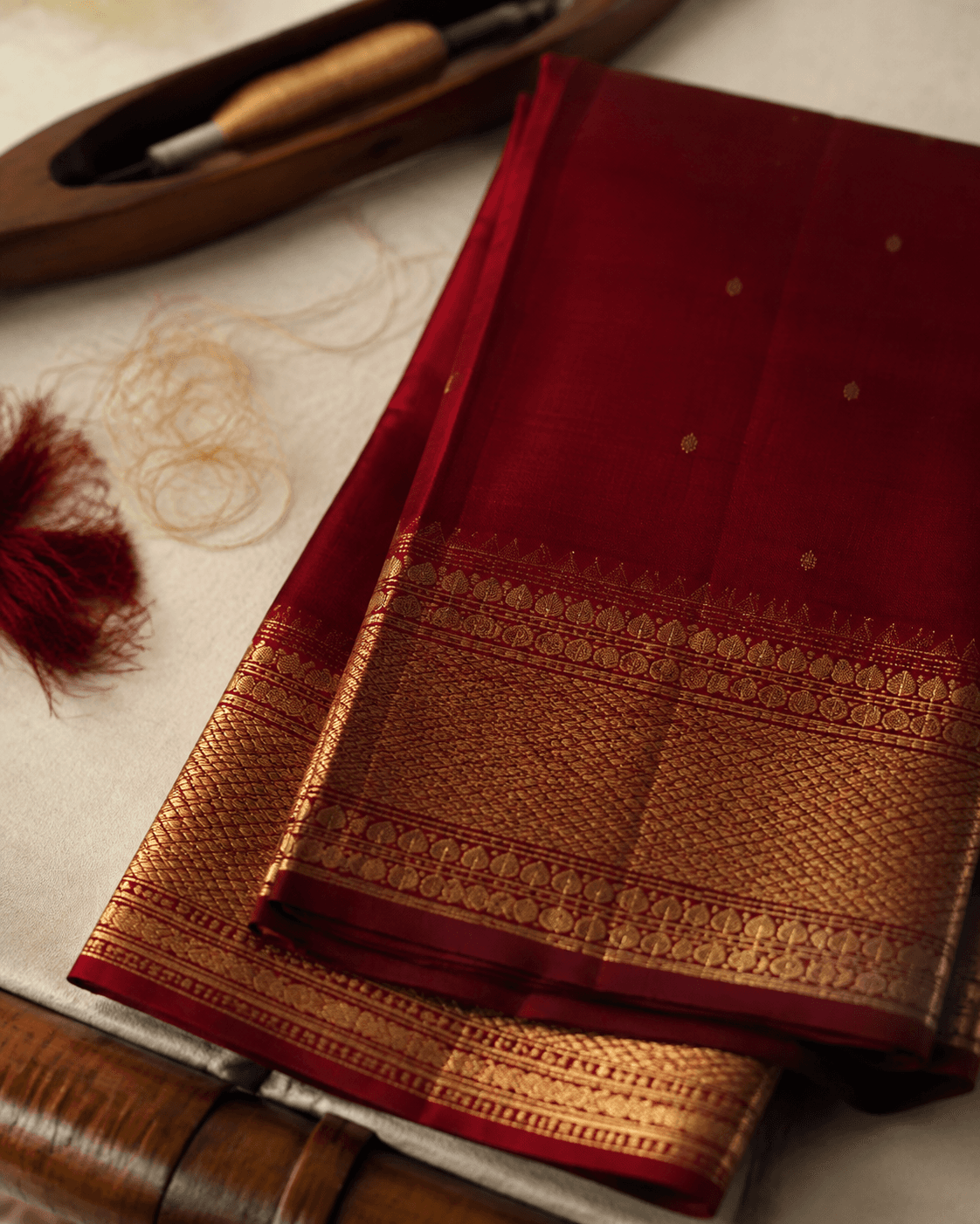 Folded crimson dress material with antique gold zari border